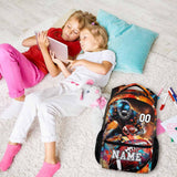 Two girls relaxing with a personalized football backpack, colorful patterns, and a cozy home setting.